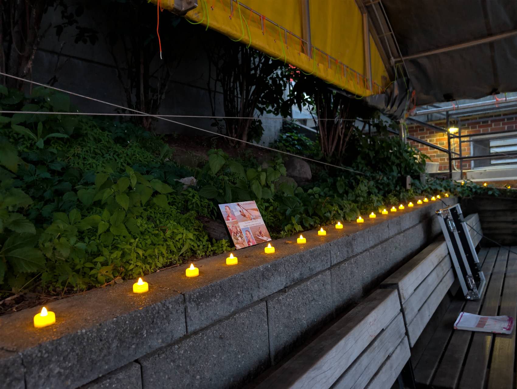 A row of candles along the stone wall at the lakefront